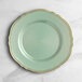 A Visions round green plastic plate with gold vintage trim.