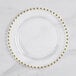 A clear plastic plate with gold beading on the rim.