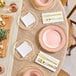 A table set with Visions clear plastic plates with gold beaded rims and gold cutlery.