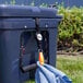 A blue cooler with a towel hanging from it using a blue and black KEY-BAK Cool-Bak tether.