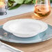 A white plastic bowl with a silver vintage rim on a table.