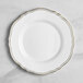 A Visions white plastic plate with a gold vintage rim.