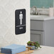 A Lavex black and white plastic men's restroom sign with braille on a wall.