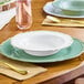 A white plastic bowl with a gold vintage rim on a table with a gold spoon.