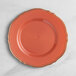 A Visions terra cotta plastic dinner plate with a gold vintage rim.