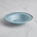 A Visions steel blue plastic bowl with a silver vintage rim on a marble surface.