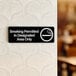 A Lavex black sign with white text that says "Smoking Permitted In Designated Areas Only"
