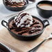 A skillet of chocolate pudding with ice cream and Monin sugar-free dark chocolate sauce.