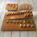 A rectangular faux bamboo melamine serving board with appetizers on it.