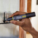A person using a Sharpie Pro black chisel tip permanent marker to draw on a wall.