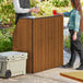 A Lancaster Table and Seating Foldaway Bar with a walnut finish set up outdoors.