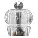A clear acrylic salt and pepper mill set on a counter.