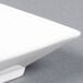 A close-up of a CAC Citysquare bright white square porcelain bowl.