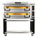 A PizzaMaster electric double deck pizza oven on a stand with yellow trays.