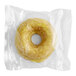 An individually wrapped Southern Roots vegan lemon cake donut in a plastic wrapper.