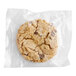 An individually wrapped Southern Roots vegan chocolate chip cookie in a plastic wrapper.