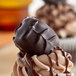 An Albanese dark chocolate covered peanut butter meltaway on top of a cupcake.