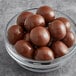 A bowl of Albanese milk chocolate covered macadamia nuts.