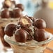 A close up of Albanese triple-dipped milk chocolate malt ball.