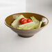 An Elite Global Solutions Pebble Creek Tapenade-colored melamine bowl filled with lettuce and tomatoes.