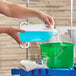 A person pouring blue liquid into a translucent HDPE jug.