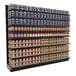 A Lozier black steel single-sided gondola shelf with cans and jars of food on it.