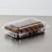 A Dart plastic container of cookies on a bakery counter.