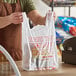 A man holding a white "Thank You" plastic T-shirt bag in front of a cash register.