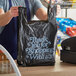 A man holding a Source Direct Inc. black plastic "Thank You" bag.