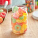 A clear round PET jar filled with colorful gummy candies.