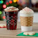 Two snowflake PET plastic cold cups with whipped cream and cookies on a table.