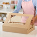 A woman holding a Southern Champion bakery box with a cake inside.