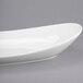 A white oval Libbey porcelain plate on a gray surface.