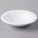 A Libbey Royal Rideau white porcelain fruit bowl on a gray surface.