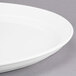 A close up of a Libbey white porcelain tray with a round rim.