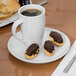 A white Libbey Slenda saucer with a cup of coffee and pastries on it.