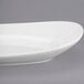 A white Libbey oval porcelain plate on a gray surface.