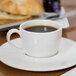 A Libbey Royal Rideau white espresso cup on a saucer with coffee.