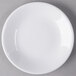 A Libbey white porcelain coupe plate on a gray surface.