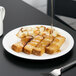 A Libbey Slenda white porcelain plate with French toast and syrup on it.