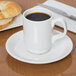 A white Libbey Slenda stacking mug of coffee on a table with a croissant.