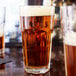 A Libbey Gibraltar cooler glass of beer on a table.