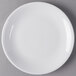 A Libbey white porcelain coupe plate with a round rim on a gray surface.