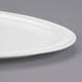 A white Libbey Triform Royal Rideau porcelain plate with curved edges.