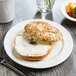 A bagel with cream cheese on a Libbey Slenda white porcelain plate.