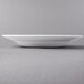 A white Libbey porcelain bowl with a rim on a gray surface.