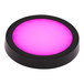 A round black Flavour Blaster LED light coaster with pink light on it.