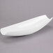 A white Libbey canoe plate with a curved edge on a gray surface.