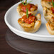 A Libbey white porcelain tray with mini appetizers including tomatoes and basil.