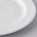 A close up of a white Libbey Slenda medium rim porcelain plate with a small hole in the middle.